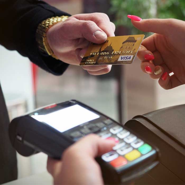 person handing over a credit card for payment
