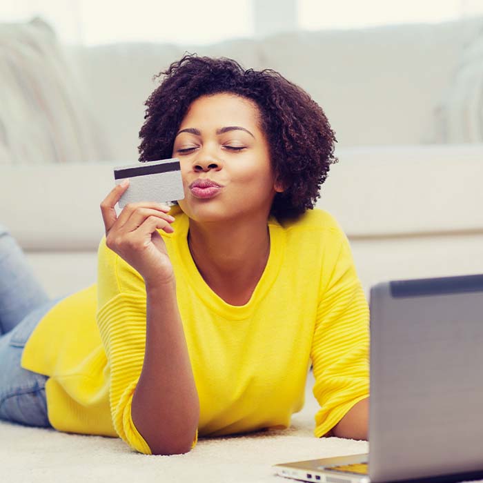 young woman blowing a kiss at her credit card